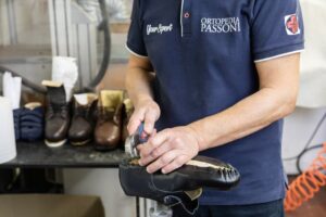 Un tecnico ortopedico sta realizzando delle calzature ortopediche su misura a Pavia.